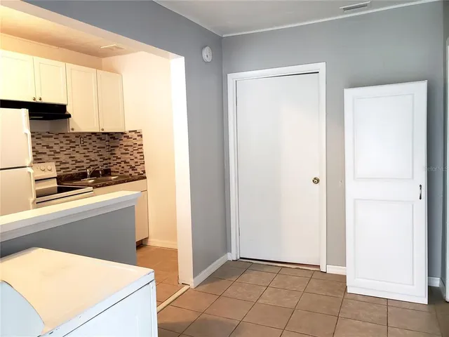 a kitchen with white cabinets and black appliances