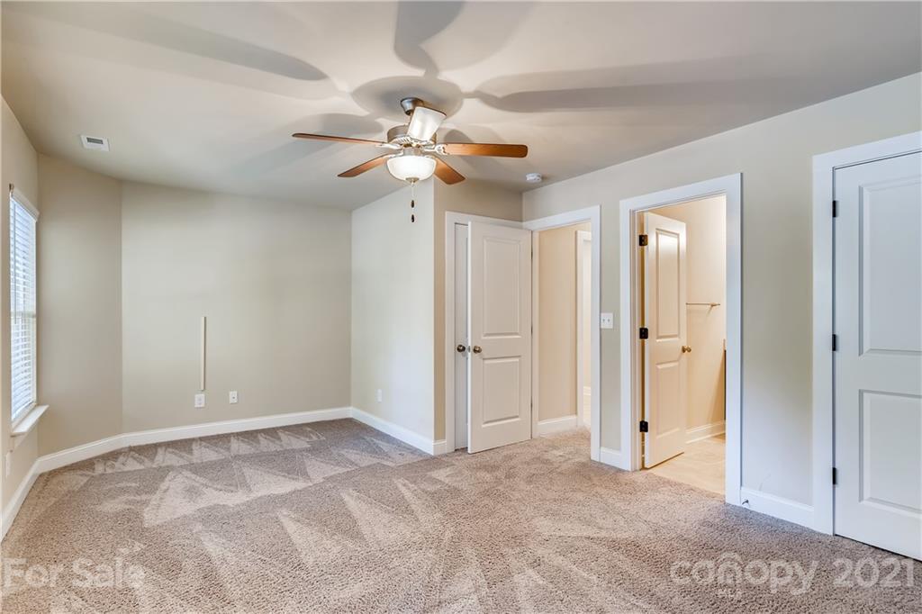 12208 Huntersville-Concord Road Huntersville, NC 28078 - Photo 19 of 33 an empty room with closet and a chandelier fan