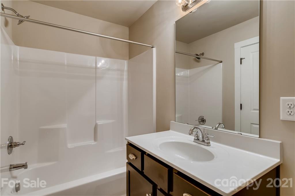 12208 Huntersville-Concord Road Huntersville, NC 28078 - Photo 27 of 33 a bathroom with a sink vanity granite tub shower and a mirror