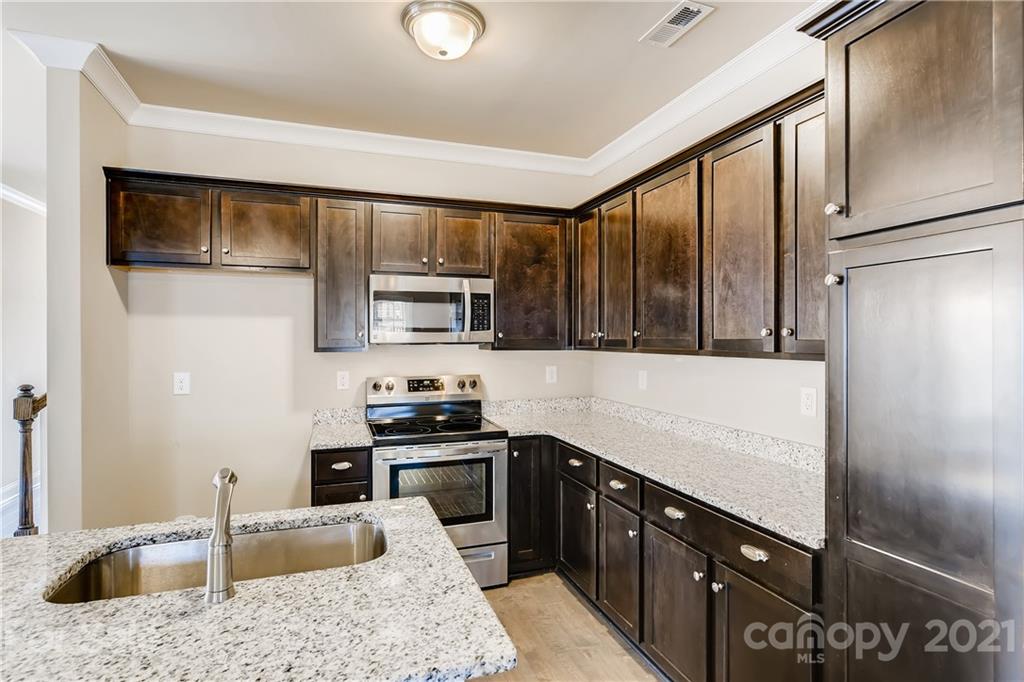 12208 Huntersville-Concord Road Huntersville, NC 28078 - Photo 10 of 33 a kitchen with stainless steel appliances granite countertop a refrigerator a sink a stove a microwave and island
