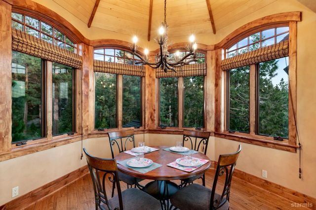 a view of a dining room with furniture large windows and a chandelier