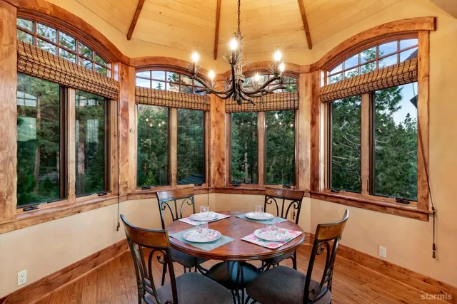 a view of a dining room with furniture large windows and a chandelier
