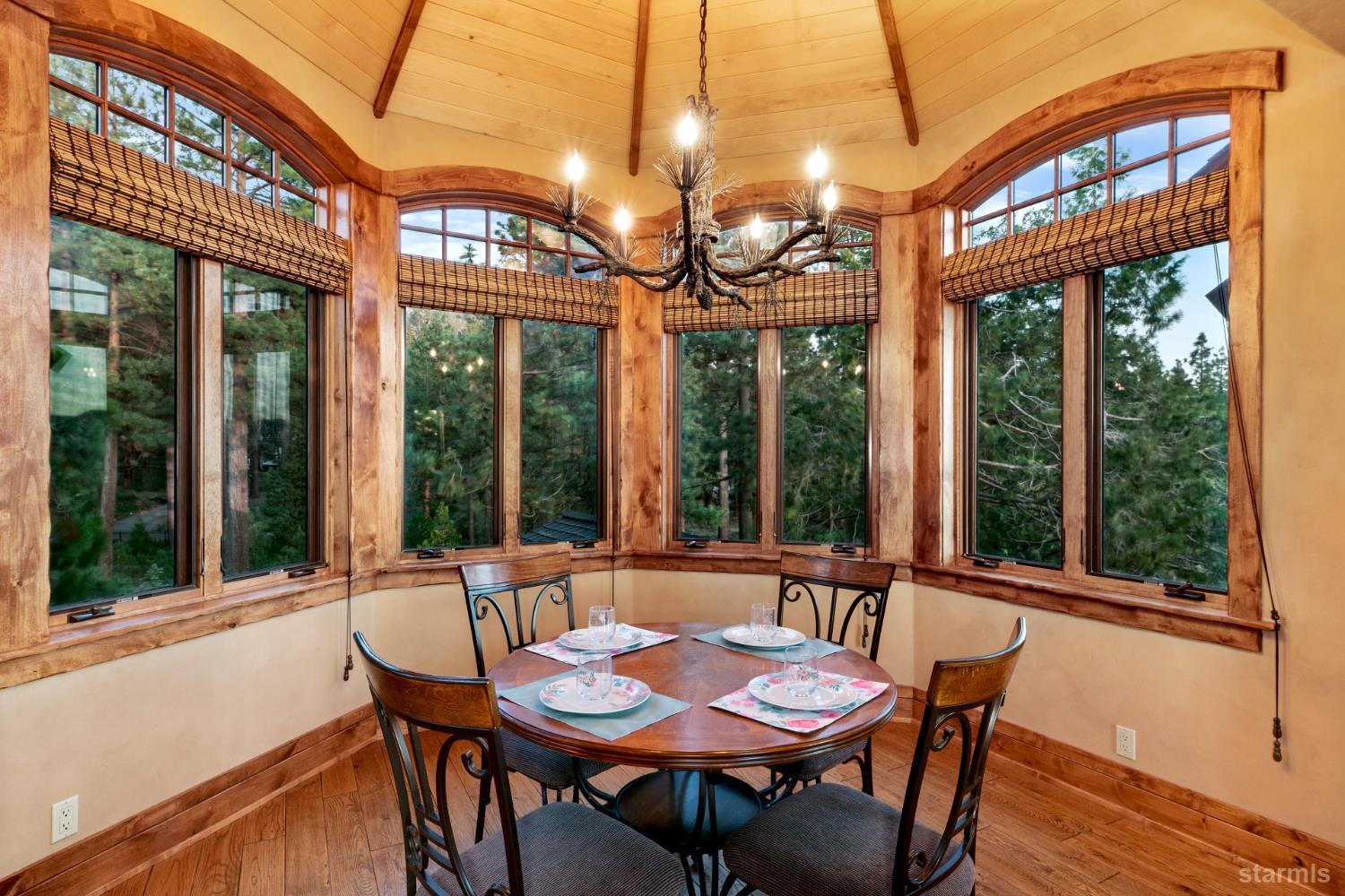 3567 Saddle Road South Lake Tahoe, CA 96150 - Photo 19 of 39 a view of a dining room with furniture large windows and a chandelier