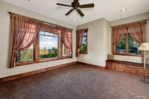 a view of an empty room with a window and a chandelier
