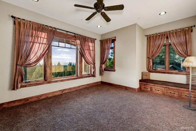 a view of an empty room with a window and a chandelier