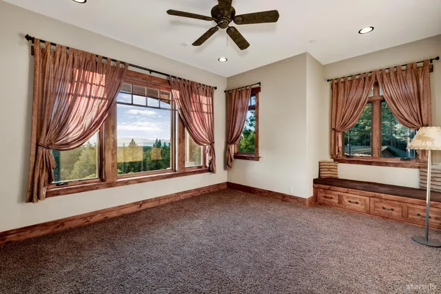 a view of an empty room with a window and a chandelier