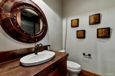 a bathroom with a toilet a sink and mirror