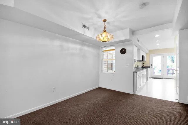 an empty room with kitchen and a window