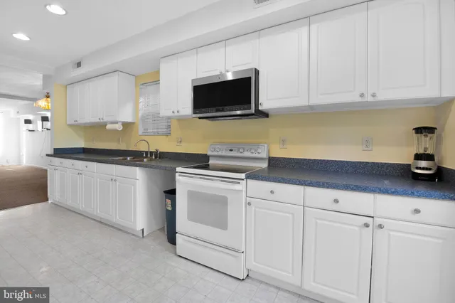 a kitchen with white cabinets and white appliances