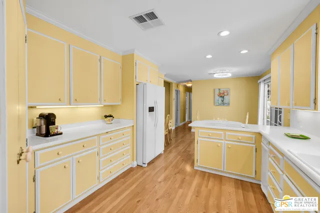 a kitchen with stainless steel appliances granite countertop a sink dishwasher stove and white cabinets with wooden floor