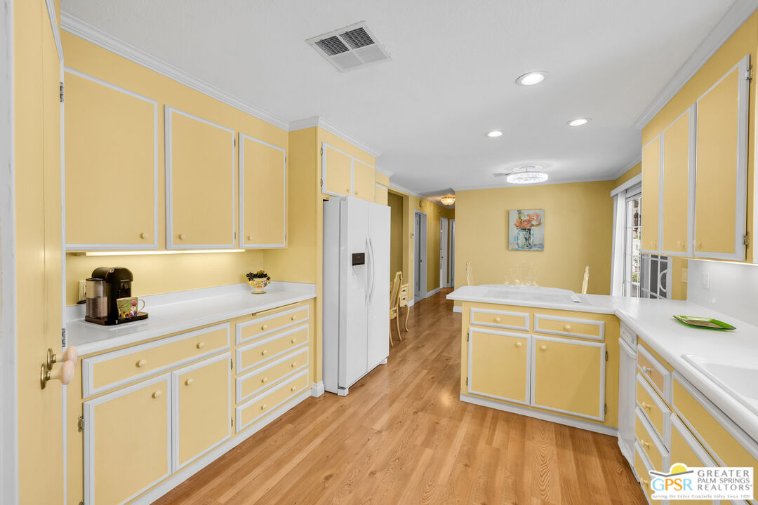 10 International Boulevard Rancho Mirage, CA 92270 - Photo 14 of 36 a kitchen with stainless steel appliances granite countertop a sink dishwasher stove and white cabinets with wooden floor