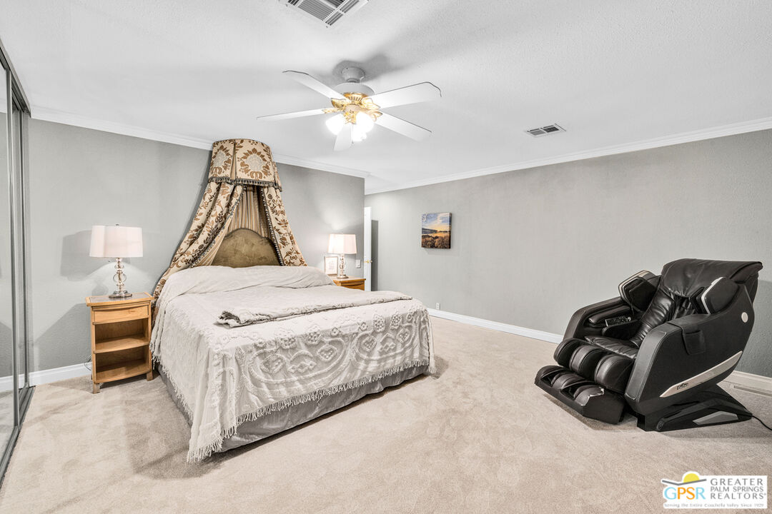 10 International Boulevard Rancho Mirage, CA 92270 - Photo 18 of 36 a bedroom with a bed and a chandelier