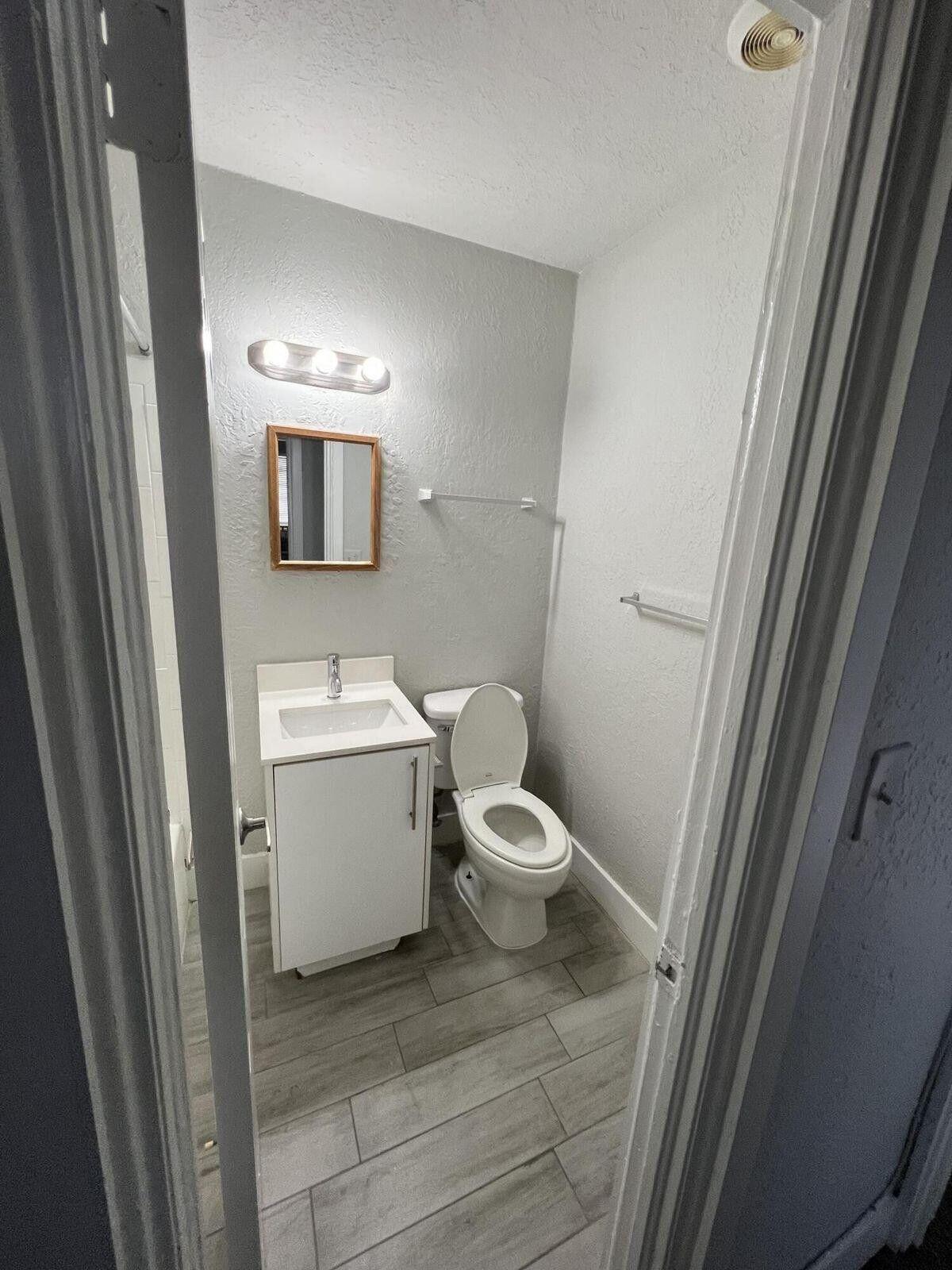 2722 Poinsettia Avenue, Unit 4 West Palm Beach, FL 33407 - Photo 5 of 6 a bathroom with a toilet sink and mirror