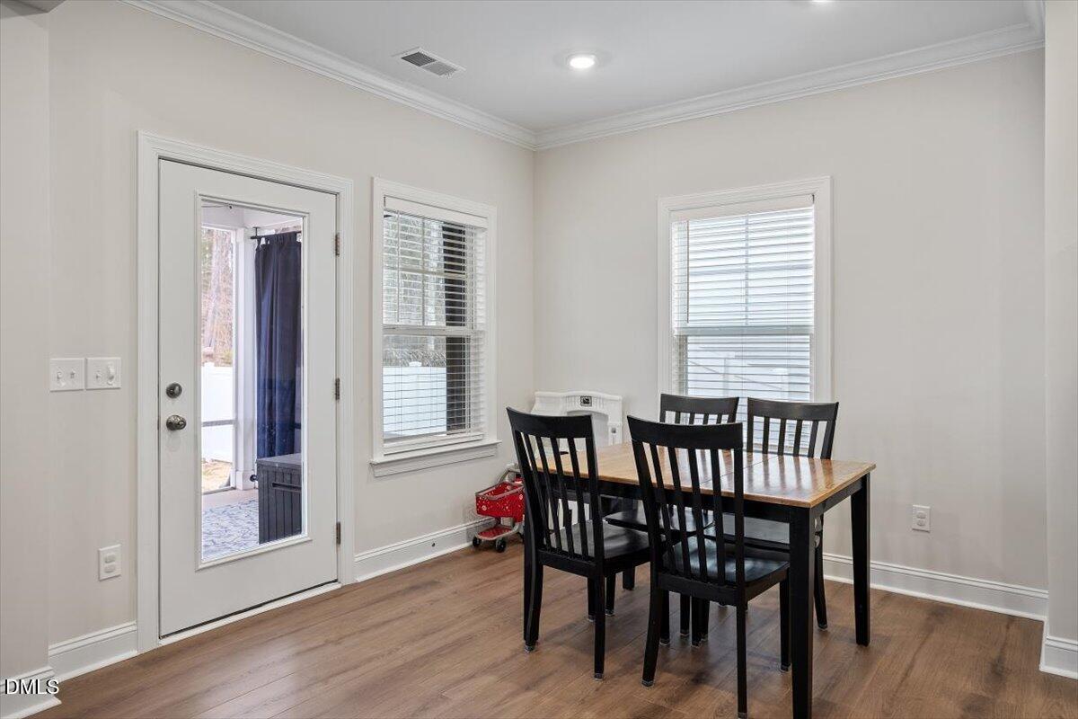 4038 Front Runner Drive Durham, NC 27703 - Photo 22 of 47 a view of a dining room with furniture window and wooden floor
