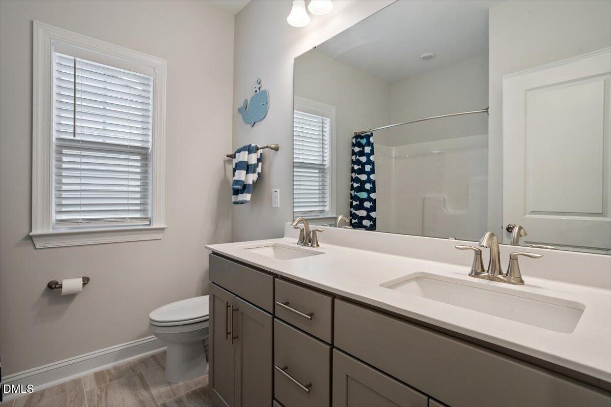 4038 Front Runner Drive Durham, NC 27703 - Photo 34 of 47 a bathroom with a sink and a mirror