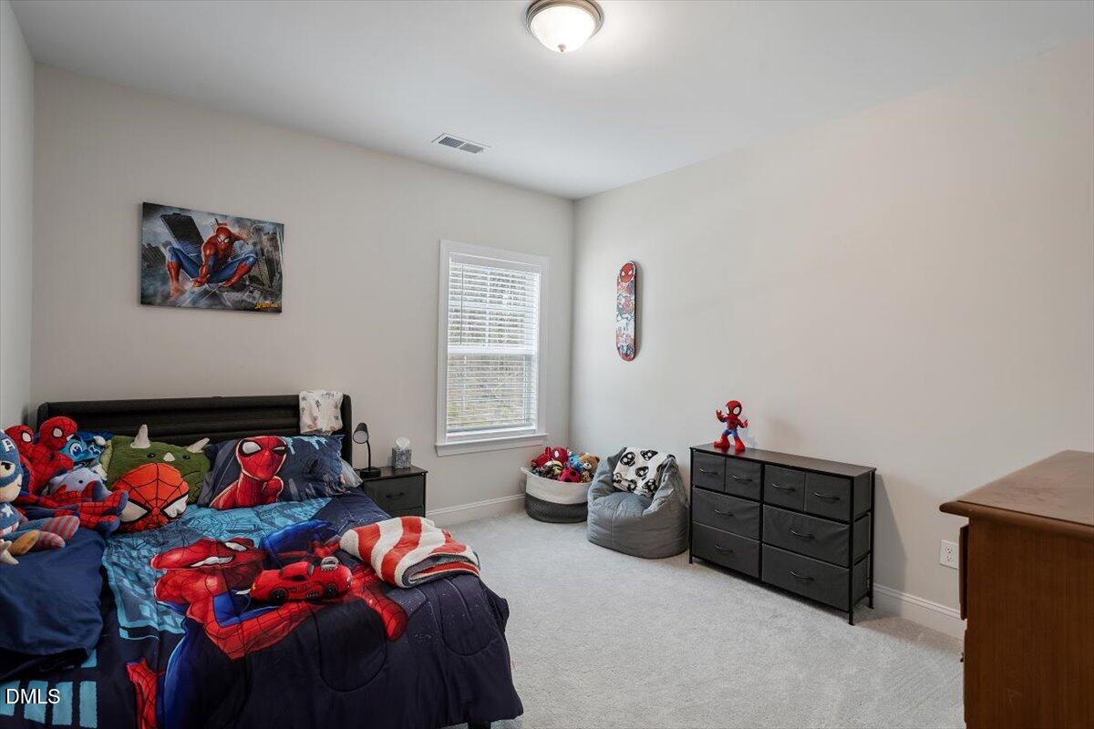 4038 Front Runner Drive Durham, NC 27703 - Photo 35 of 47 a bedroom with a bed and cabinets