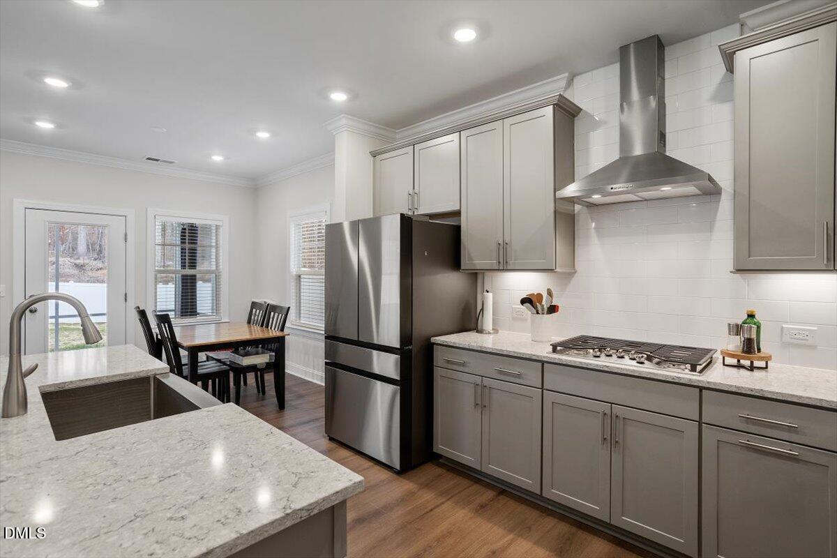 4038 Front Runner Drive Durham, NC 27703 - Photo 5 of 47 a kitchen with stainless steel appliances granite countertop a refrigerator a sink dishwasher a dining table and chairs with wooden floor