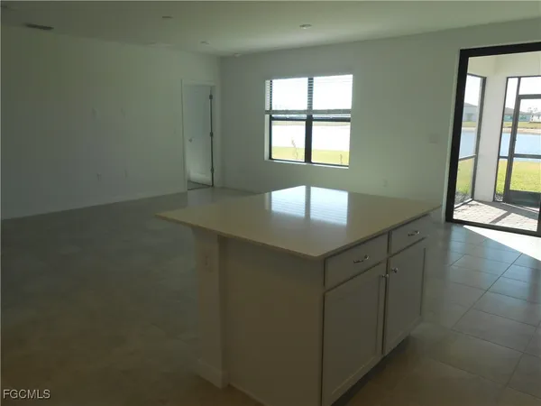 an empty room with windows and chandelier