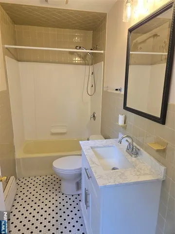 a bathroom with a granite countertop sink a toilet a mirror and shower