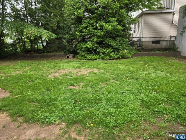 a view of backyard with barbeque grill and a small yard