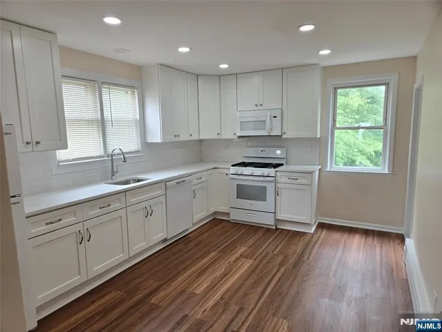 a kitchen with wooden floors and white appliances