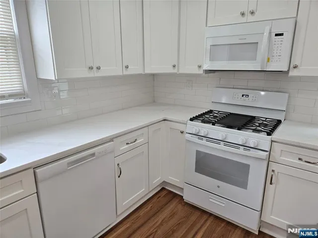a kitchen with white cabinets and white appliances