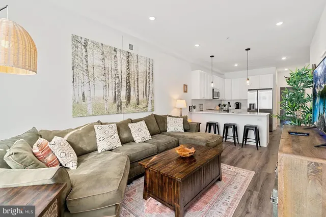 a living room with furniture and kitchen view