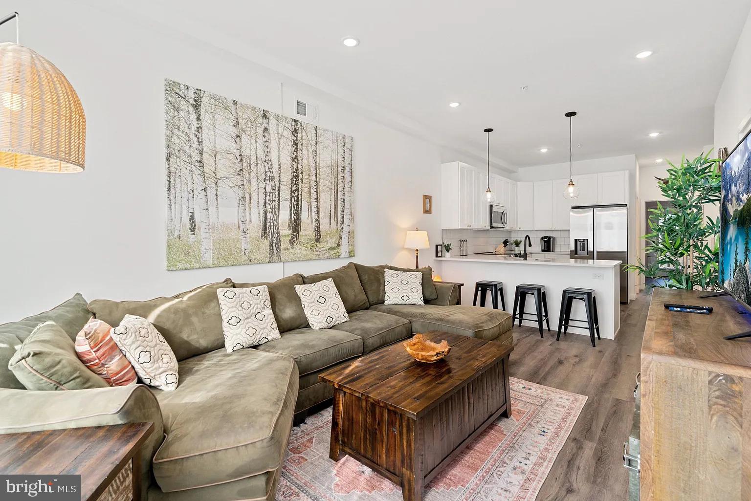 a living room with furniture and kitchen view