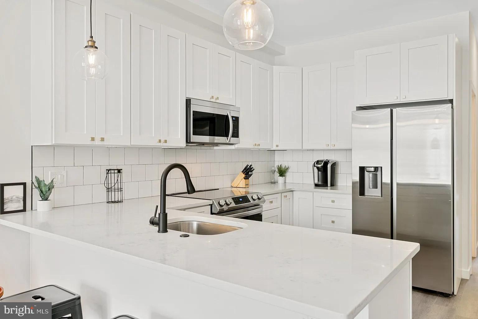 1735 South 23rd Street, Unit 2 Philadelphia, PA 19145 - Photo 4 of 17 a kitchen with stainless steel appliances a refrigerator sink and white cabinets