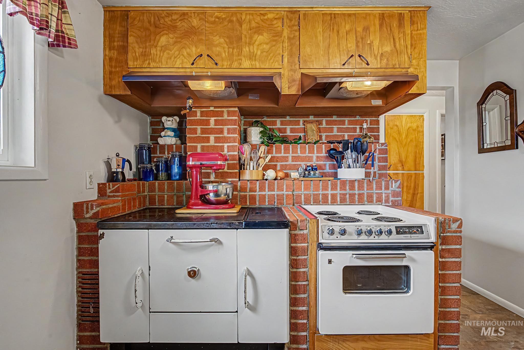 4311 Frozen Dog Road Emmett, ID 83617 - Photo 14 of 31 Kitchen featuring brick accents, wood cabinetry, and a built-in electric range with oven