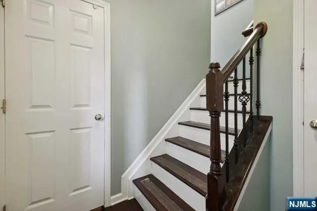 a living room with couches and kitchen view with wooden floor