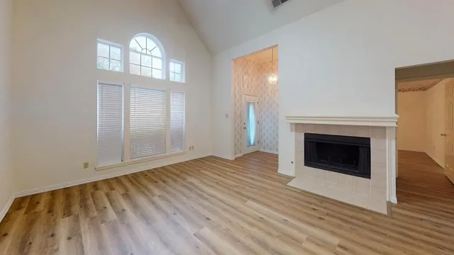 an empty room with wooden floor and fireplace