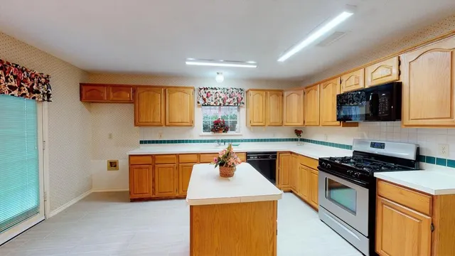 a kitchen with stainless steel appliances a sink a stove top oven a counter space and cabinets