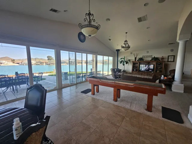 a living room with furniture a table and large windows