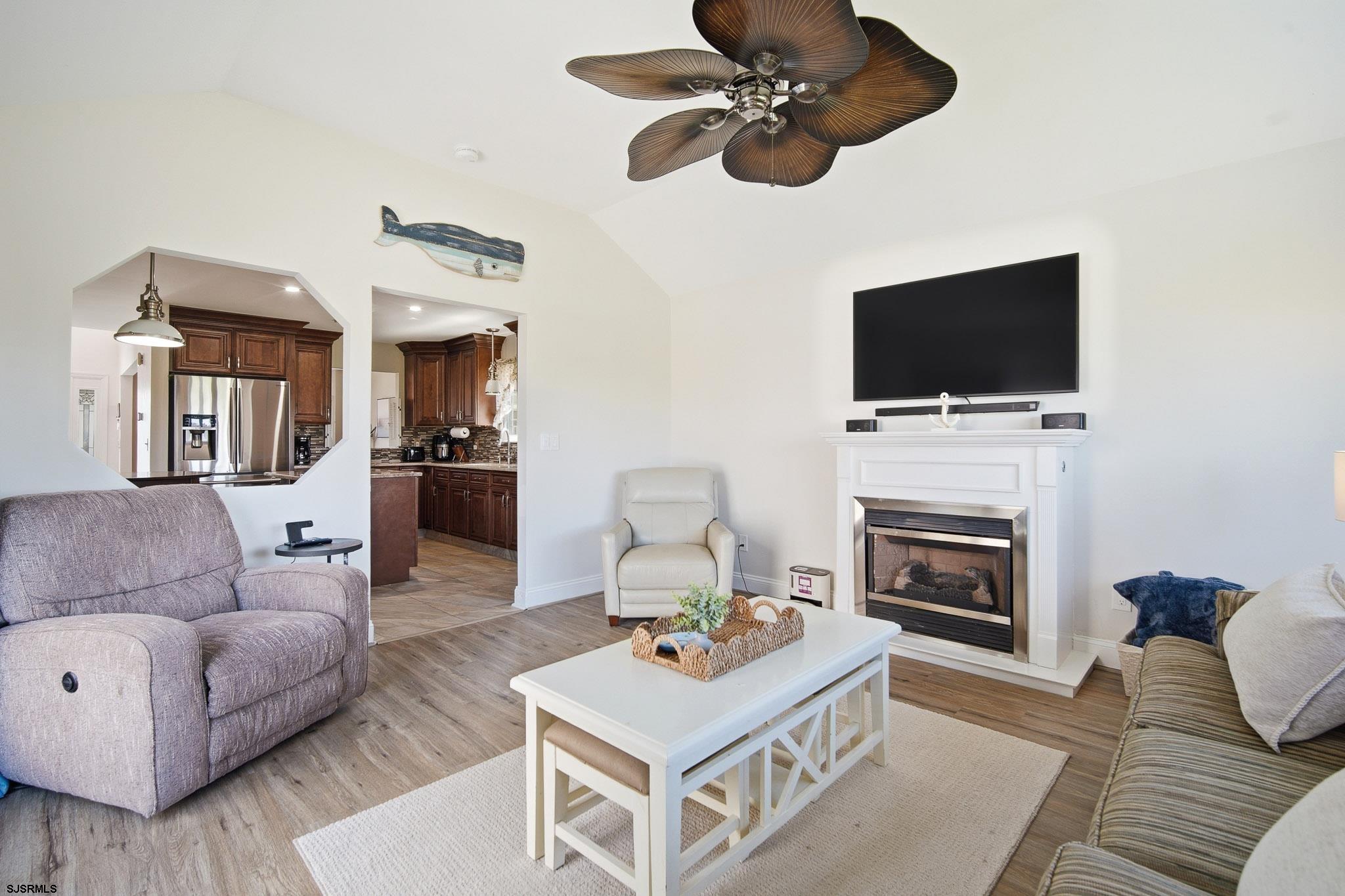 214 Hagen Road Brigantine, NJ 08203 - Photo 5 of 34 a living room with furniture a fireplace and a flat screen tv