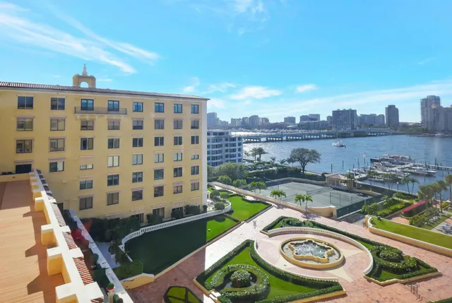 a view of a swimming pool with lawn chairs and plants