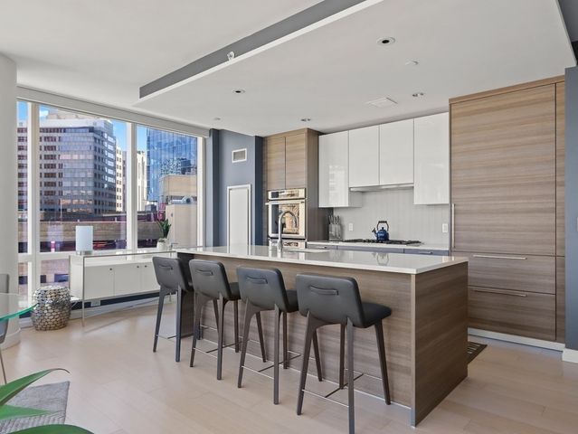 a kitchen with a sink and chairs