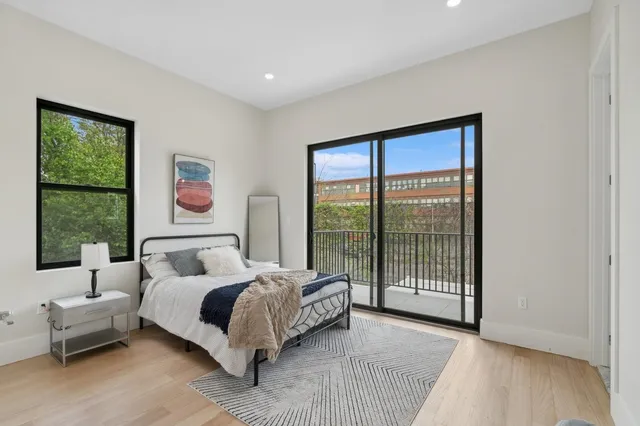 a bedroom with a bed and a large window