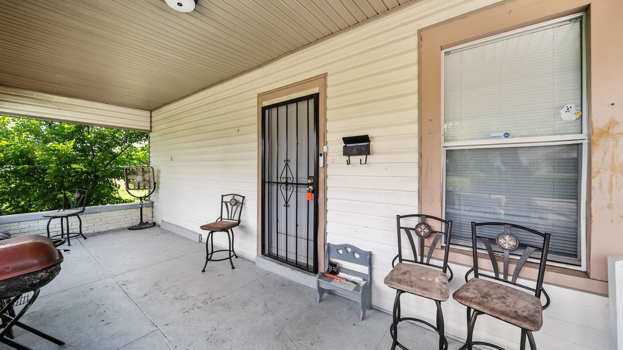 659 Decatur Street Memphis, TN 38107 - Photo 4 of 24 Covered front porch featuring a security screen door, large window with blinds, and durable siding