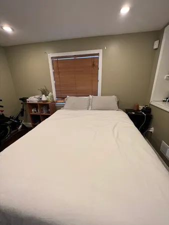 a bedroom with a bed and a large mirror