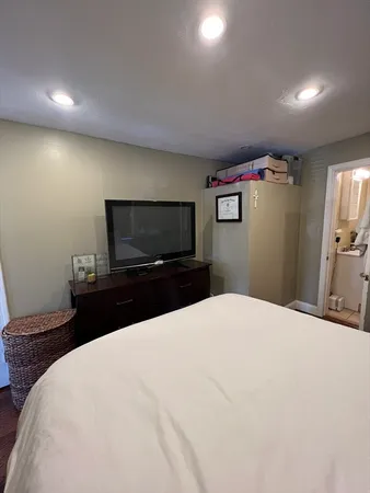 a bedroom with a bed and a flat screen tv