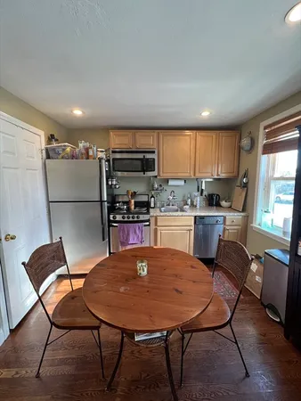 a kitchen with a table chairs a sink dishwasher and a refrigerator