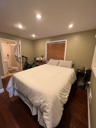a bed sitting in a spacious bedroom next to a window