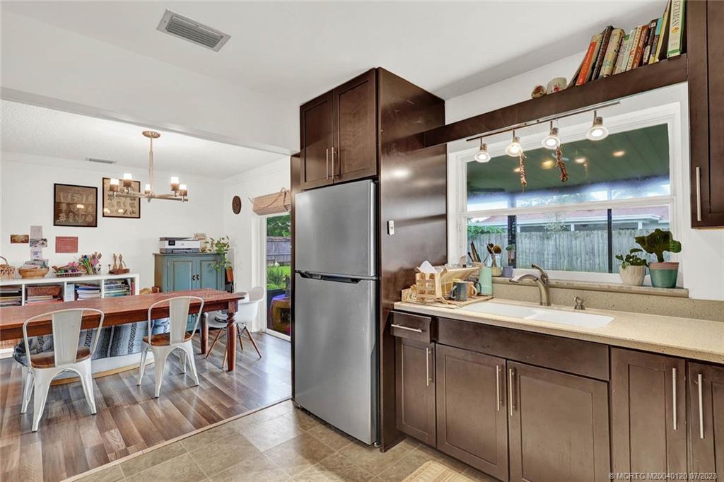 1790 Southeast Madison Street Stuart, FL 34997 - Photo 11 of 24 a kitchen with stainless steel appliances a dining table chairs and granite counter tops