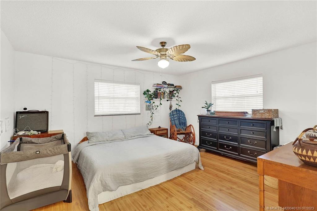 1790 Southeast Madison Street Stuart, FL 34997 - Photo 12 of 24 a bedroom with a bed and wooden floor