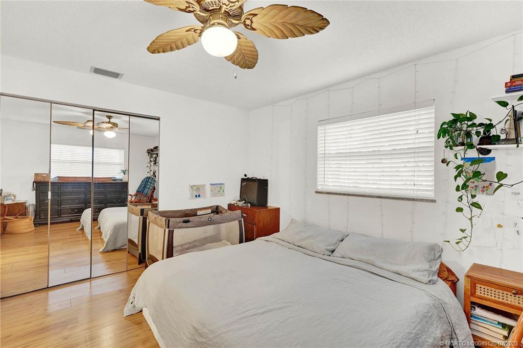 1790 Southeast Madison Street Stuart, FL 34997 - Photo 13 of 24 a bedroom with a bed and ceiling fan