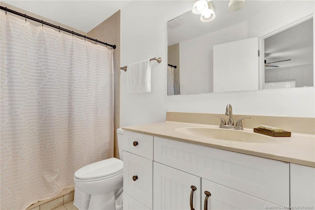 1790 Southeast Madison Street Stuart, FL 34997 - Photo 19 of 24 a bathroom with a granite countertop sink and a mirror