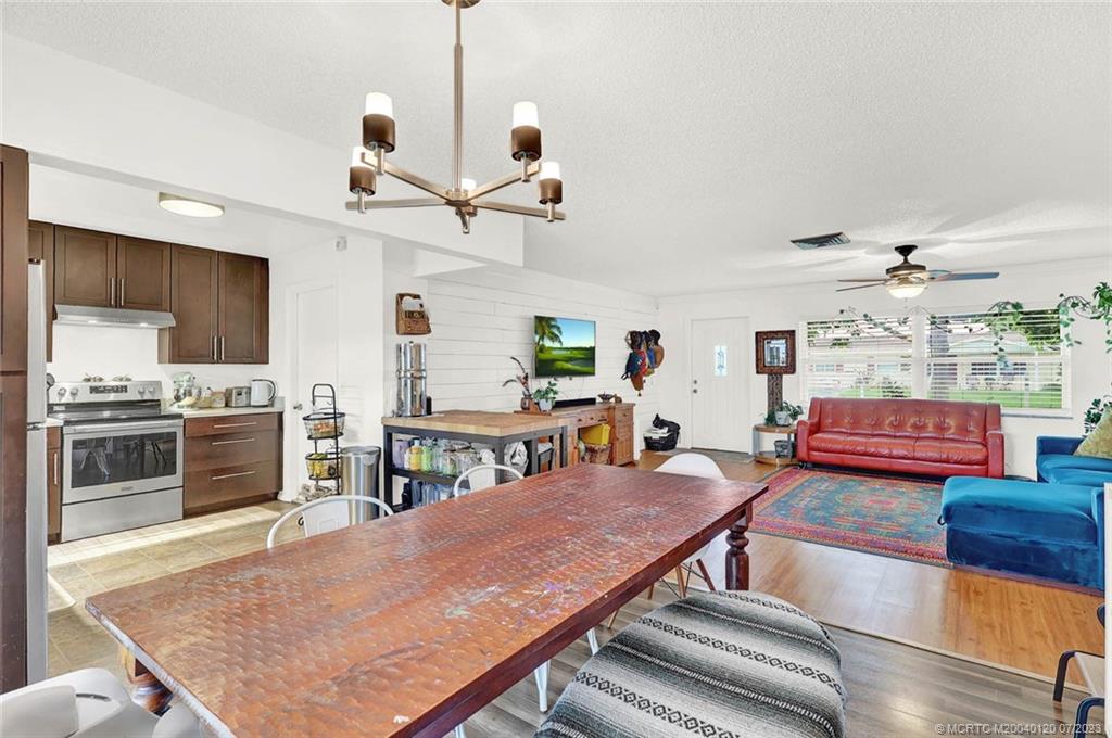 1790 Southeast Madison Street Stuart, FL 34997 - Photo 8 of 24 a living room with fireplace a flat screen tv and kitchen view