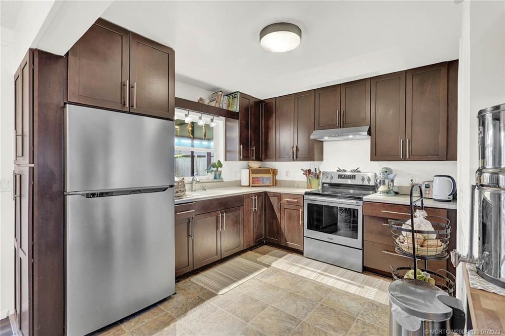 1790 Southeast Madison Street Stuart, FL 34997 - Photo 9 of 24 a kitchen with stainless steel appliances granite countertop a refrigerator stove a sink and dishwasher