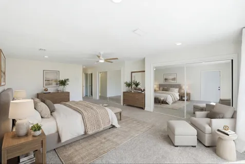 a spacious bedroom with a bed and ceiling fan